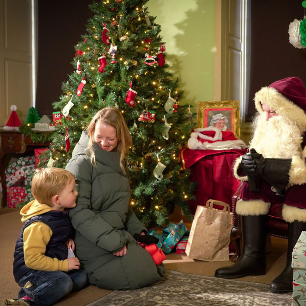 mum and child sitting on the floor talking to father christmas