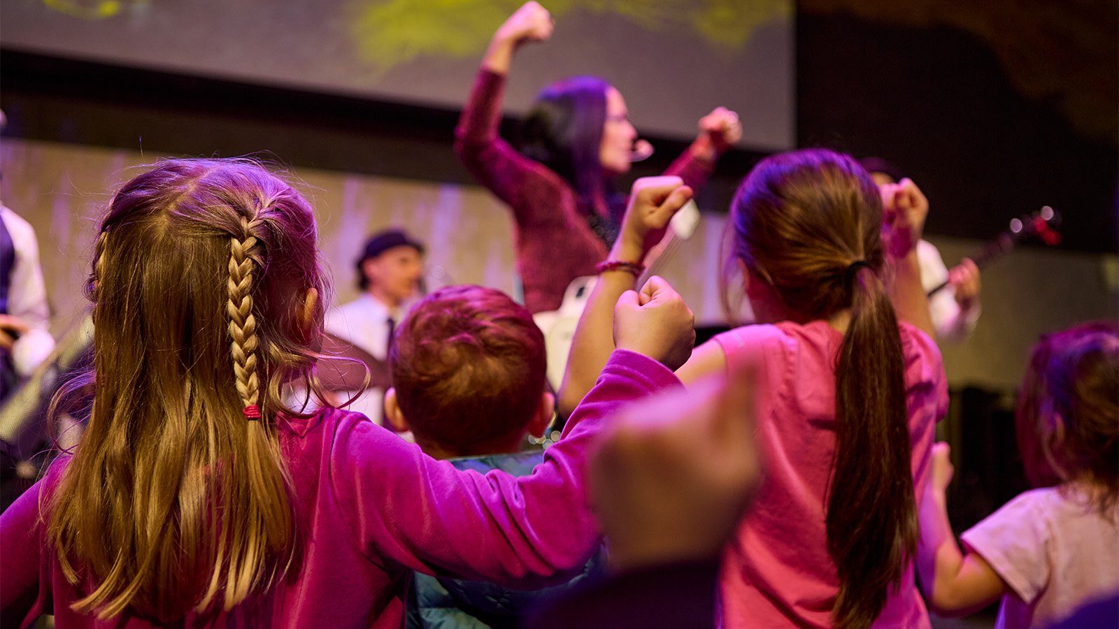 Kids dance watching an act on stage