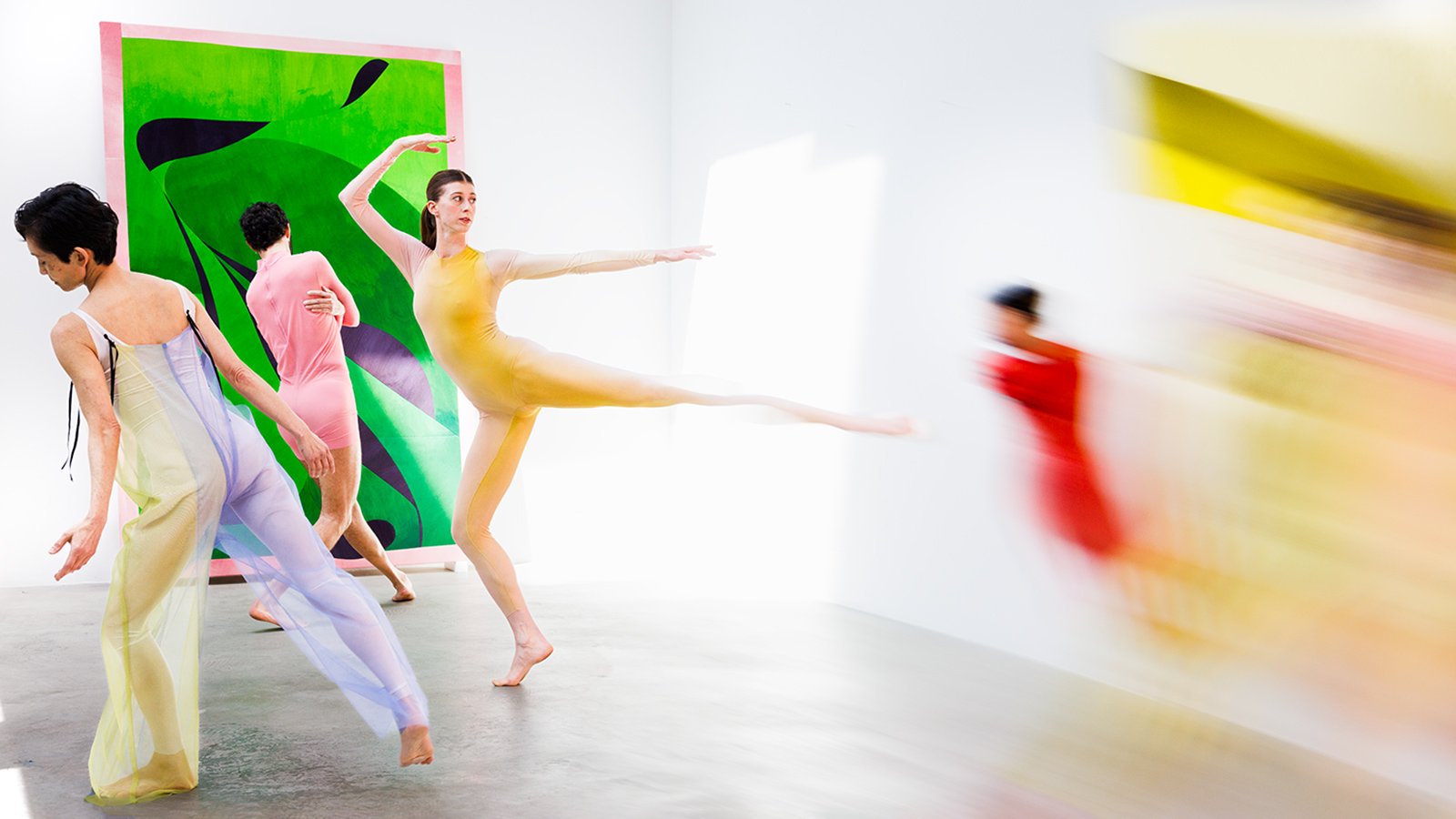 Pastel-clad dancers leap across a beautiful studio