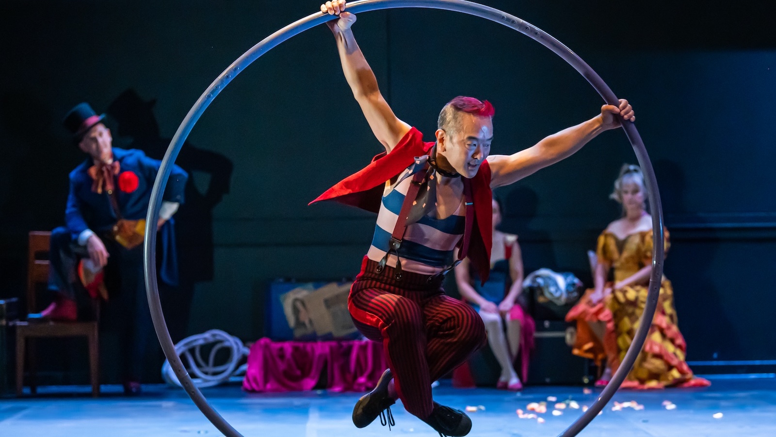 An acrobat riding a large metal ring