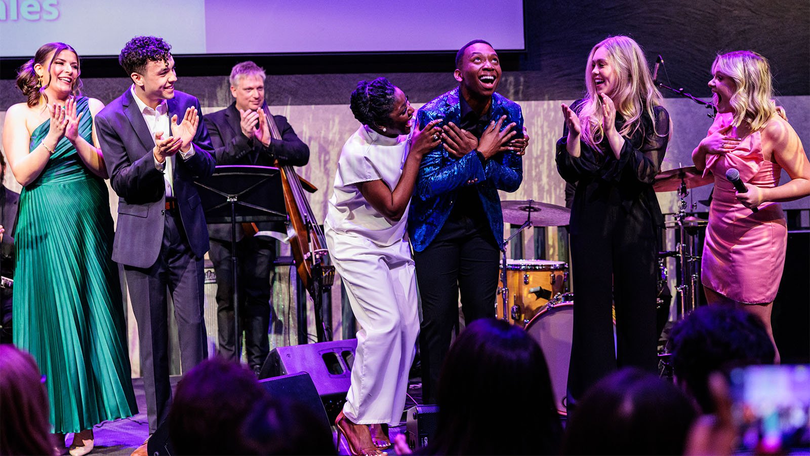 Group of performers applauding on the stage at the Atrium