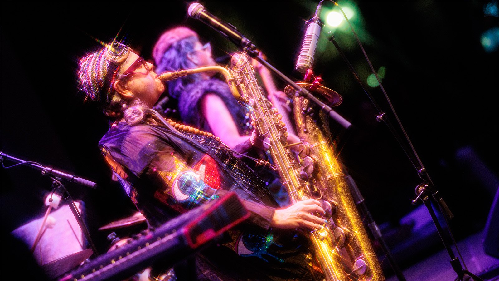 Person in a glittery outfit playing saxophone 