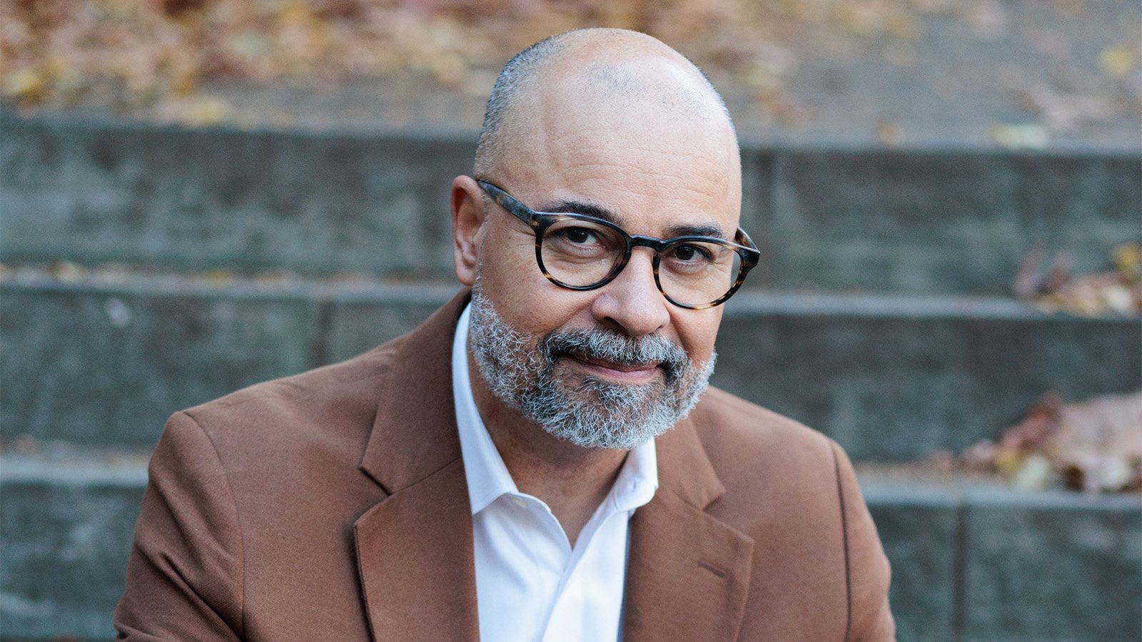 A man with glasses smiles 