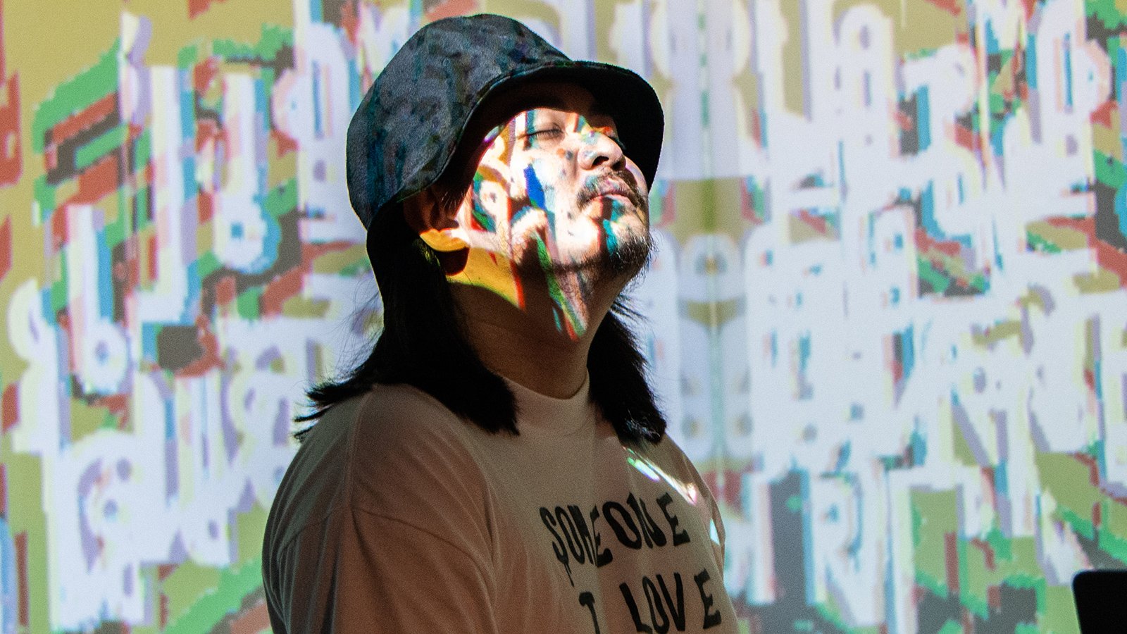 A man with long black hair wearing a black brimmed hat