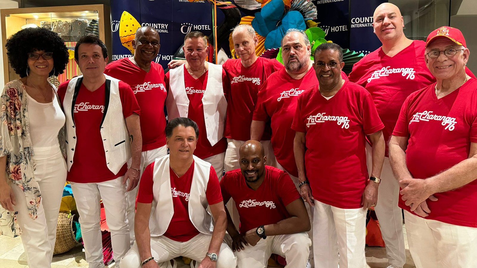 A group of people wearing red t-shirts and white pants