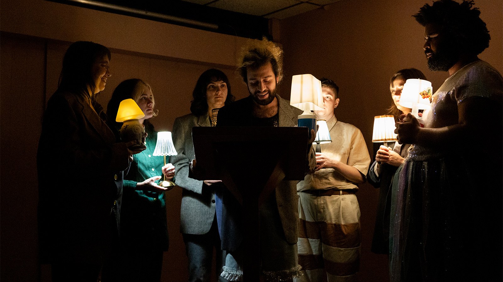 A group performs holding lamps