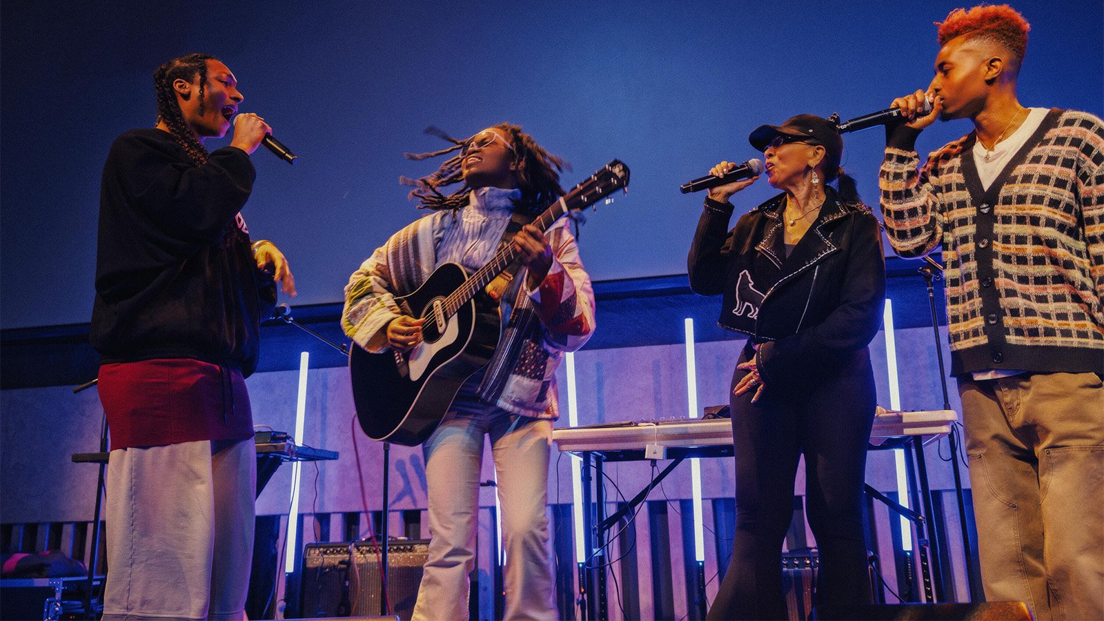 Four singers and a guitarist stage