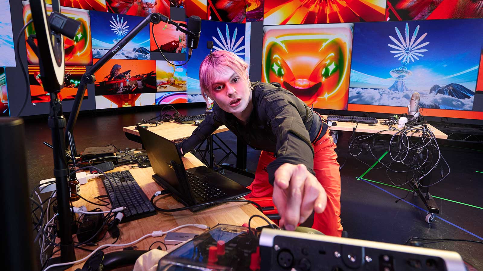 A person with pink hair at a computer