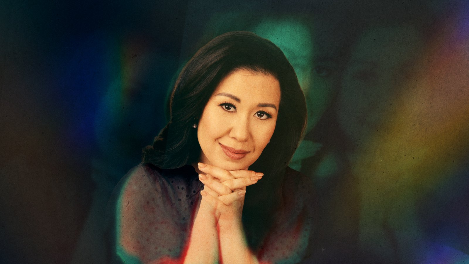 woman with hands folded under chin