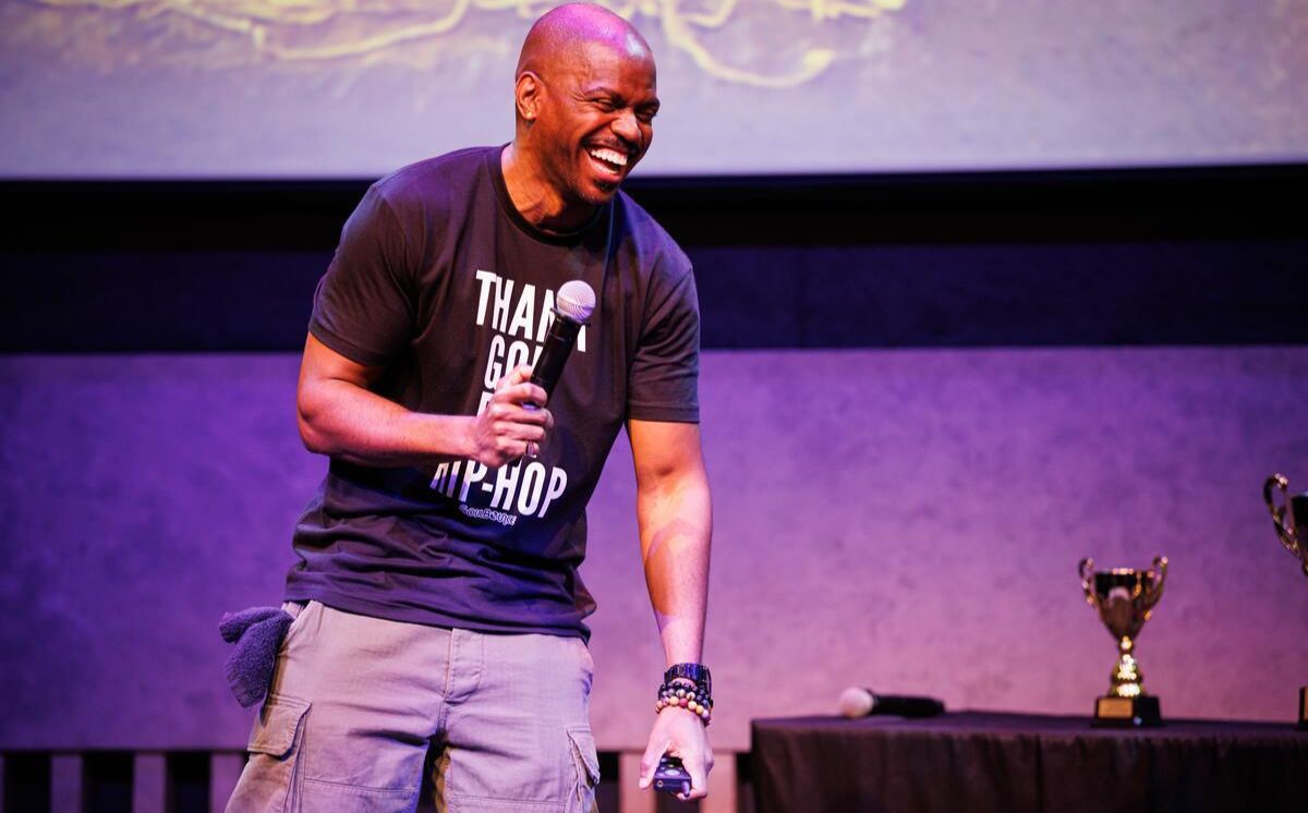 A black man performing on stage at the Atrium