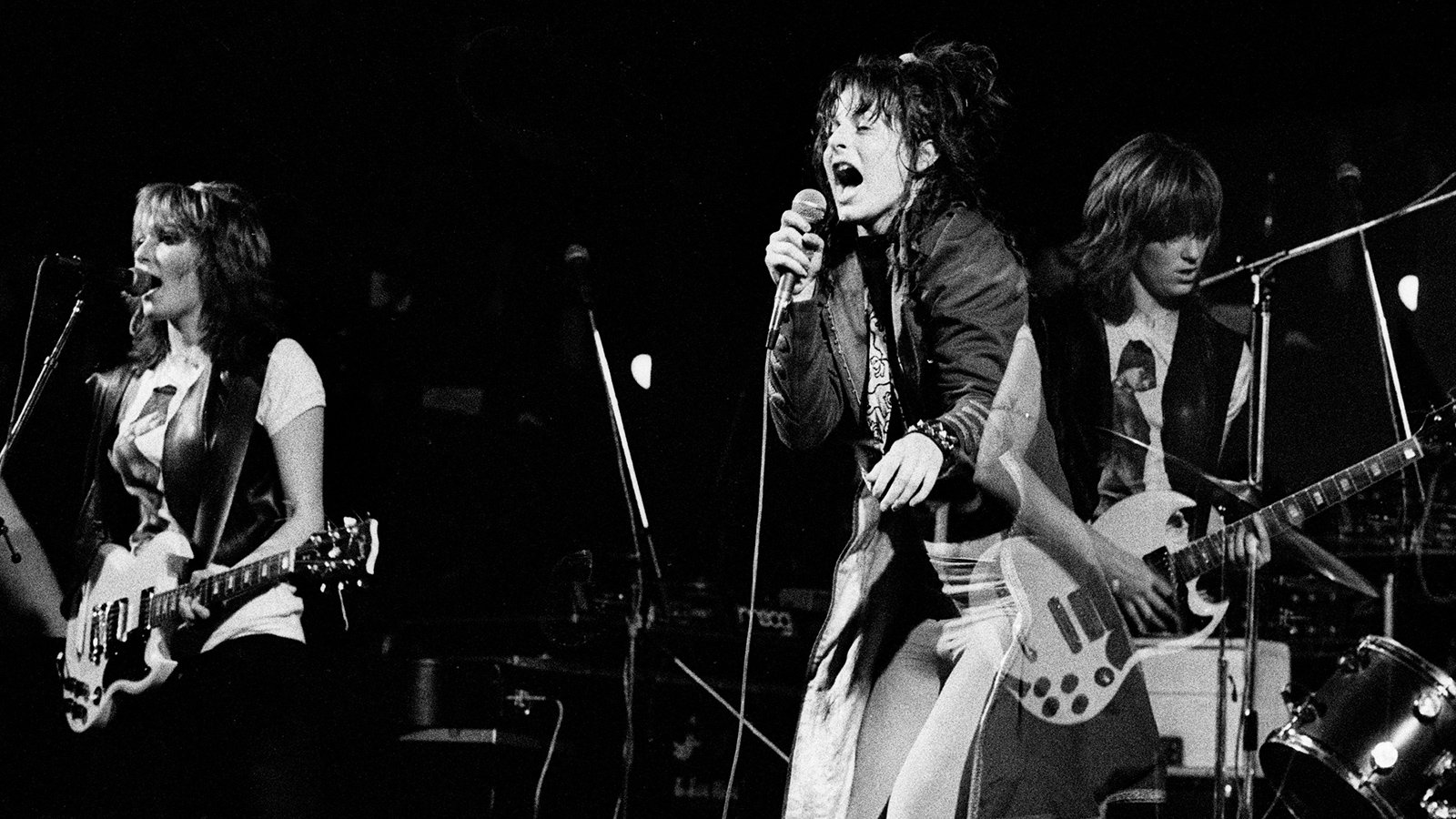 A black and white photo of The Slits performing on stage