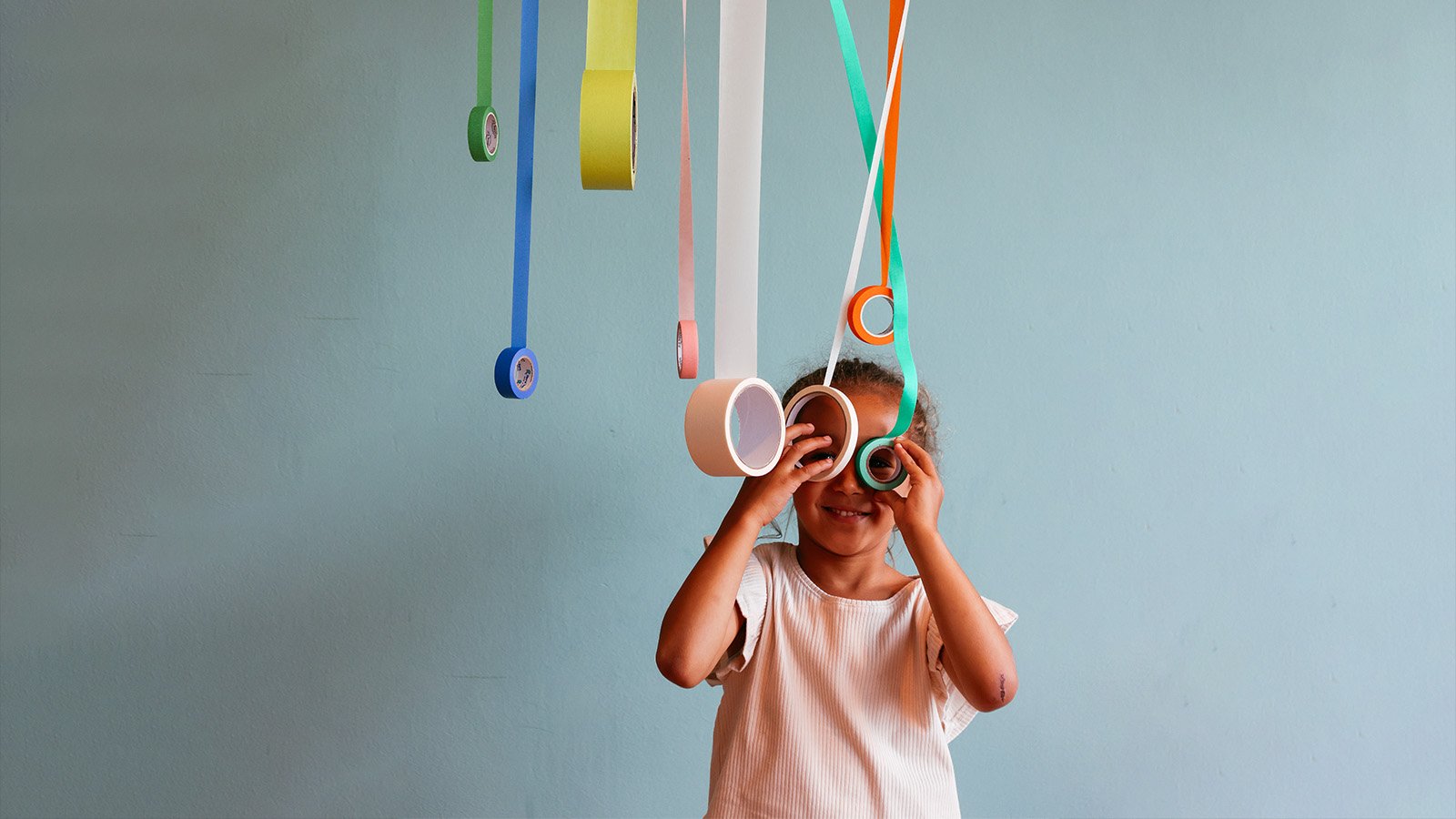 A kid plays with different colored tape