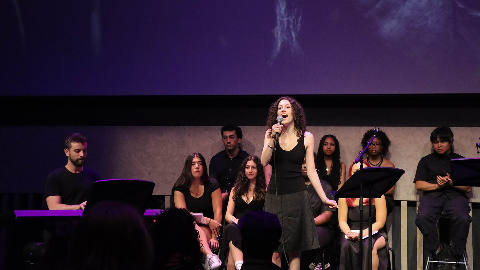 A group of people sing on stage