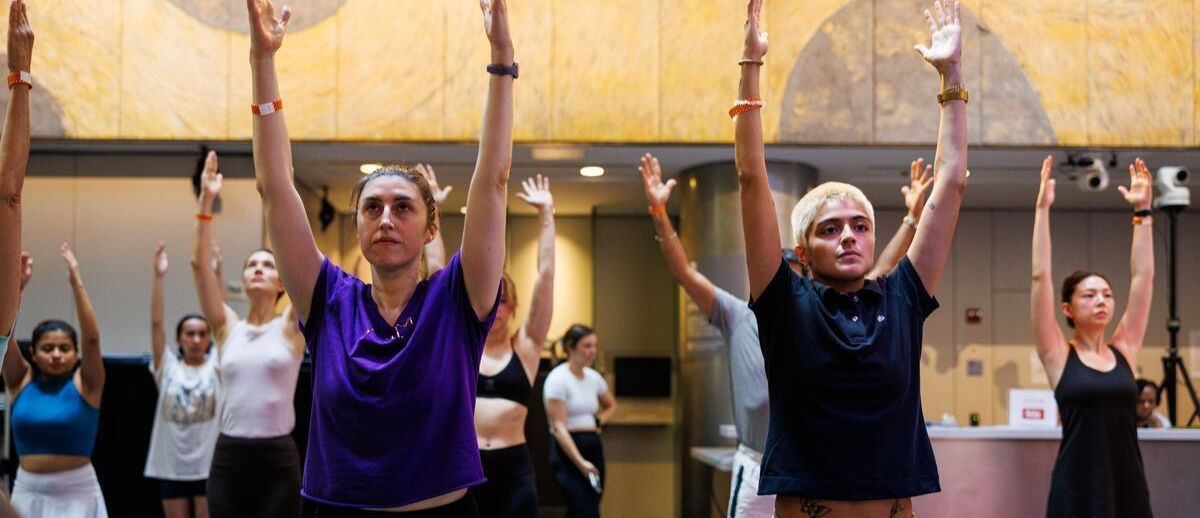 A group of people pose in a yoga class in the Atrium.