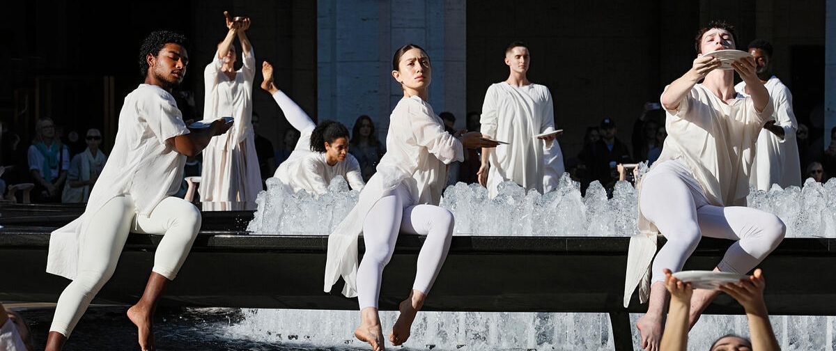 Dancers dressed all in white move around the fountain in Josie Robertson Plaza.