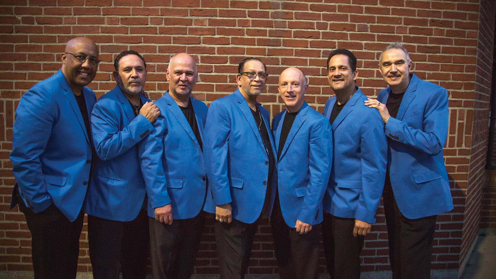 A seven-member band poses together 