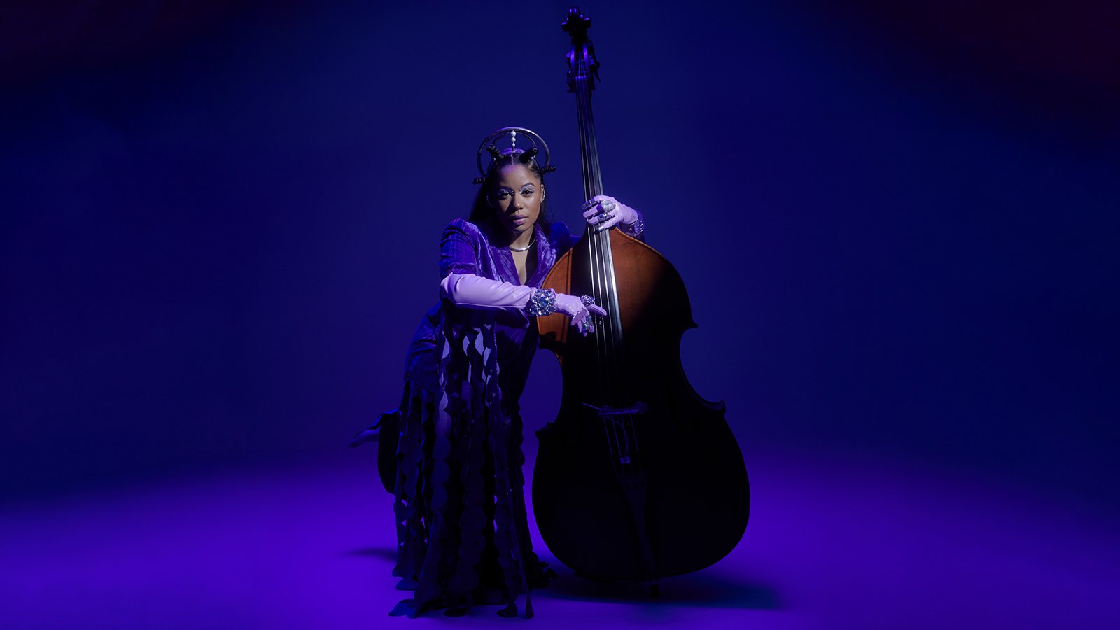 A teenage girl with braces holds up a sign that says "PROM QUEEN" with the letter & R spray-painted over the N, spelling PROM QUEER