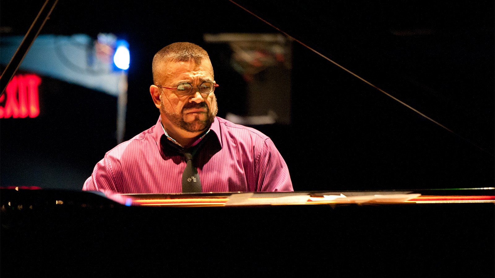 A teenage girl with braces holds up a sign that says "PROM QUEEN" with the letter & R spray-painted over the N, spelling PROM QUEER