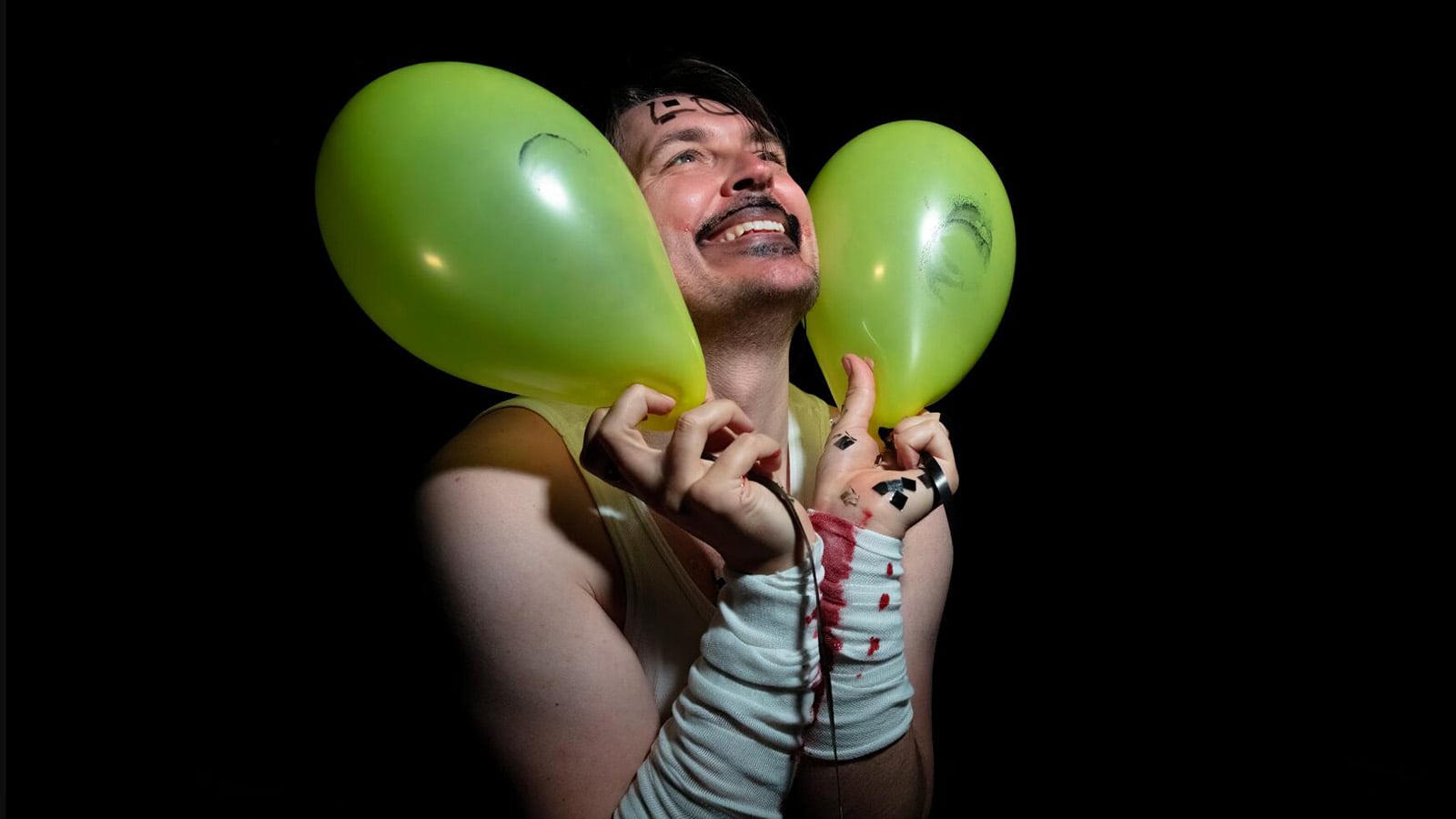 A person holds two balloons dramatically