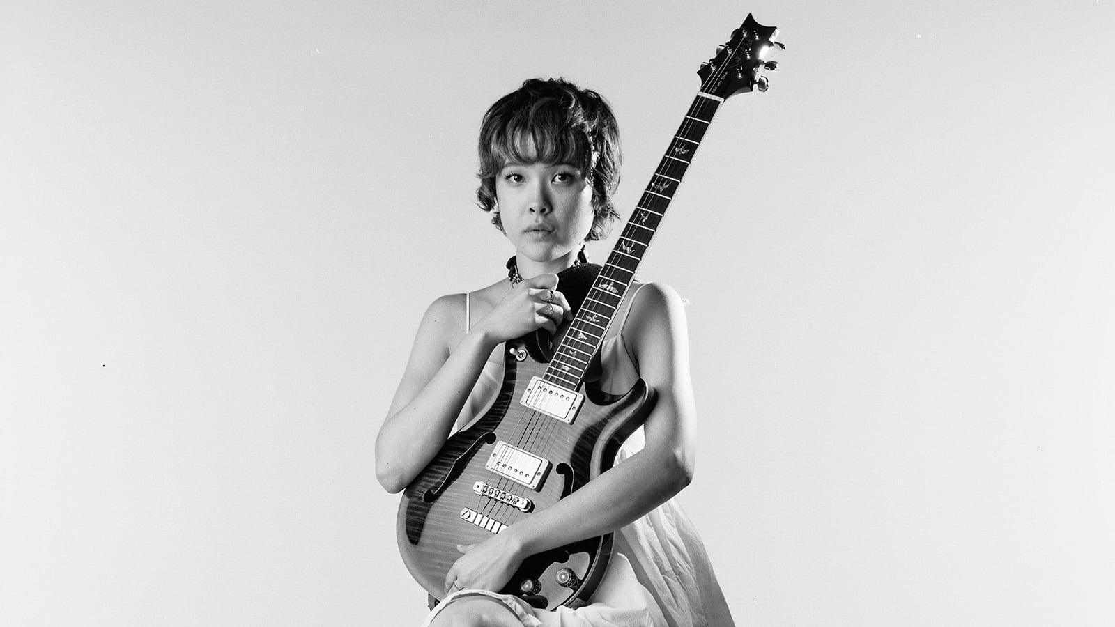 A woman holds a guitar
