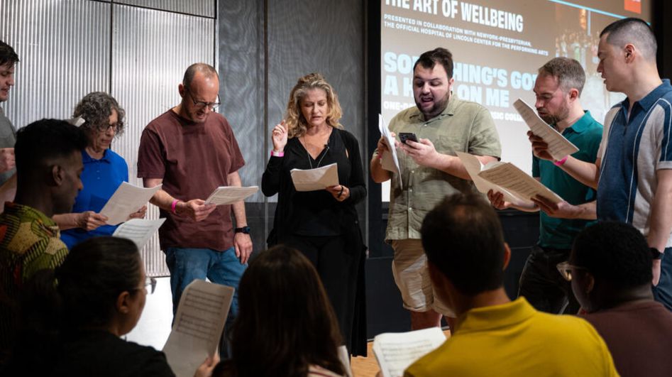 A group of singers read sheet music 