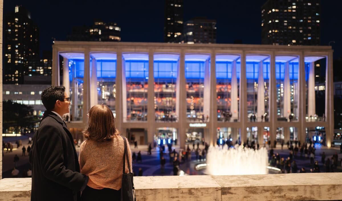 A couple looks on to the plaza at night