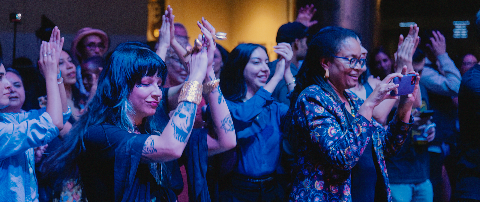 Audience members dance and clap