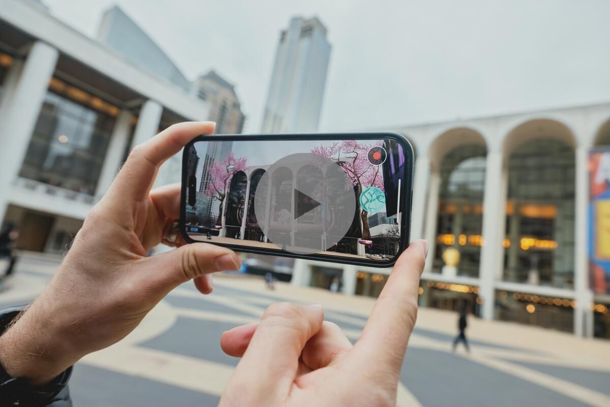 A person holding their phone up to the Metropolitan Opera