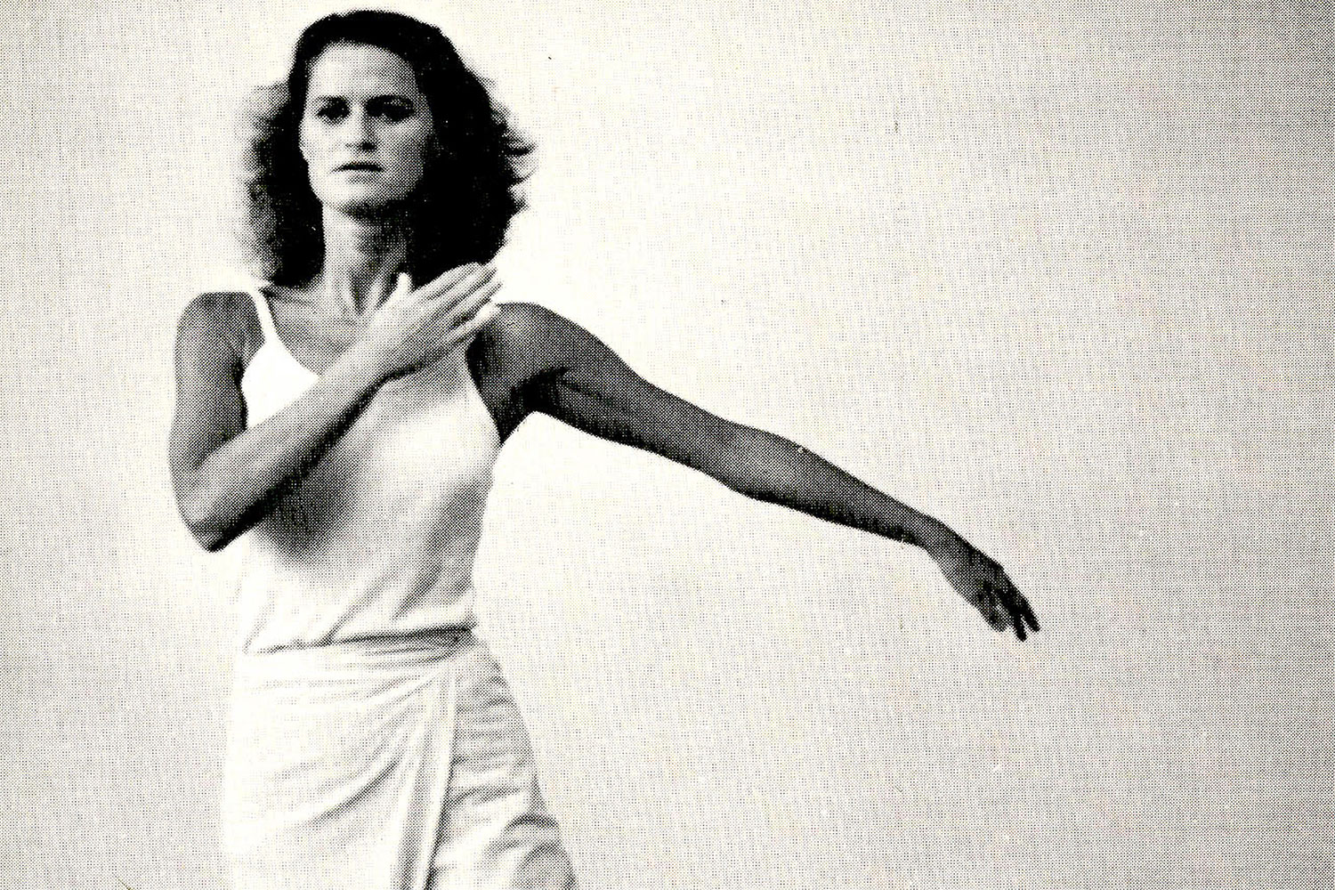 Black and white photo of a woman dancing in a white dress