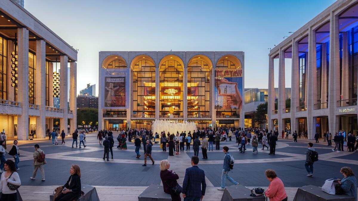 People walking through the Lincoln Center plaza at night