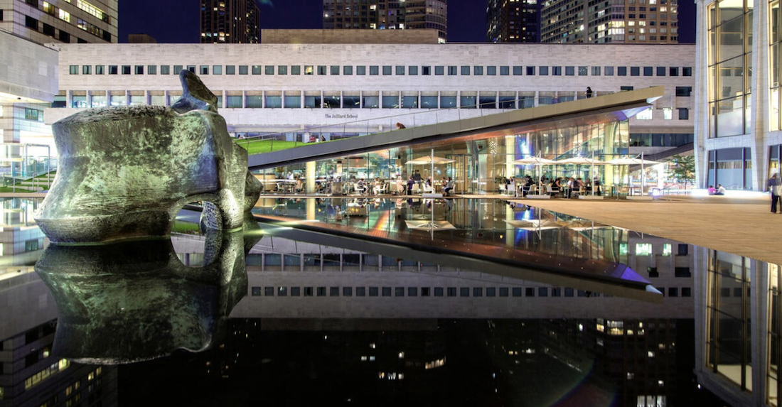 People walking through the Lincoln Center plaza at night