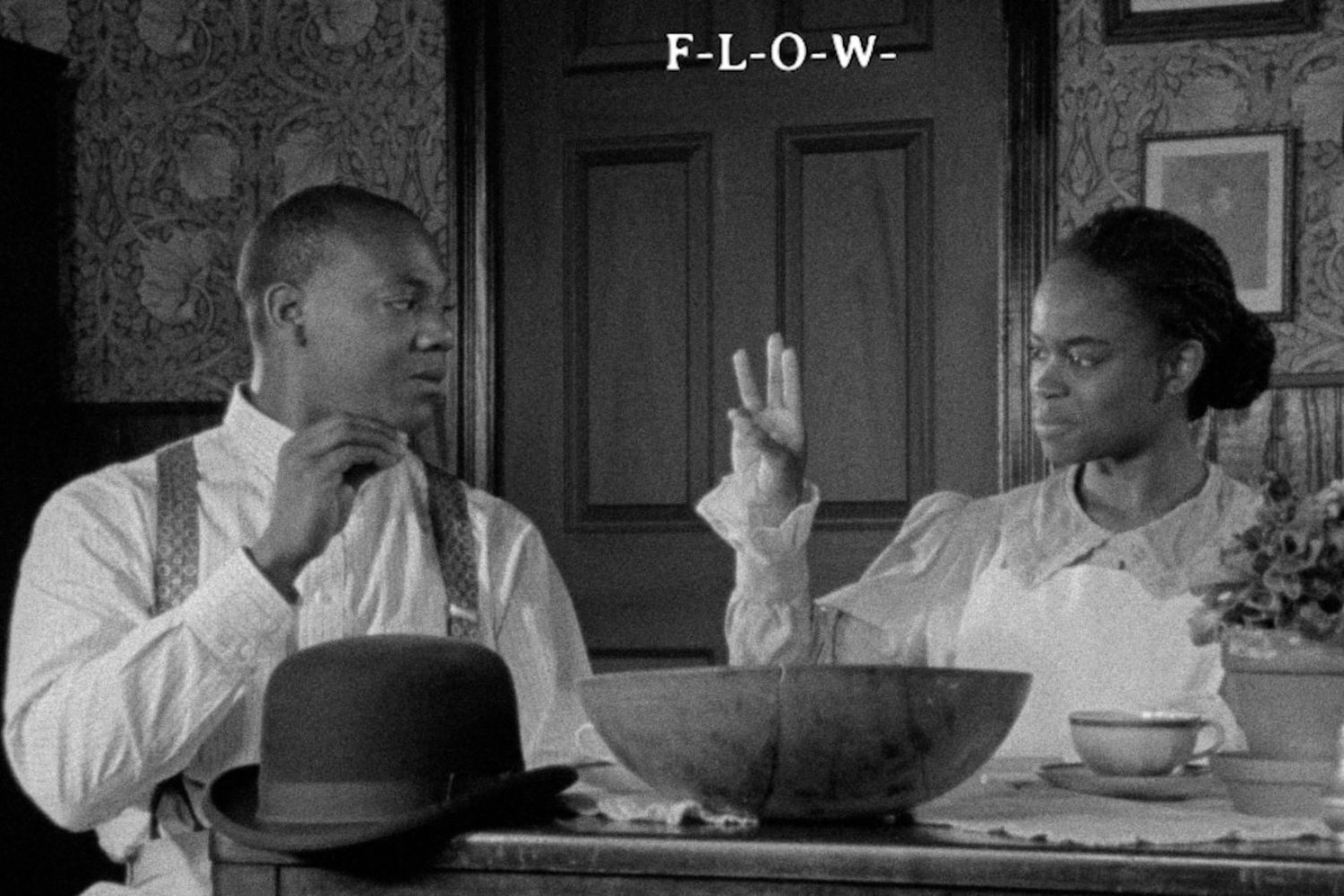 Black and white photo of a black man and woman sitting at a table