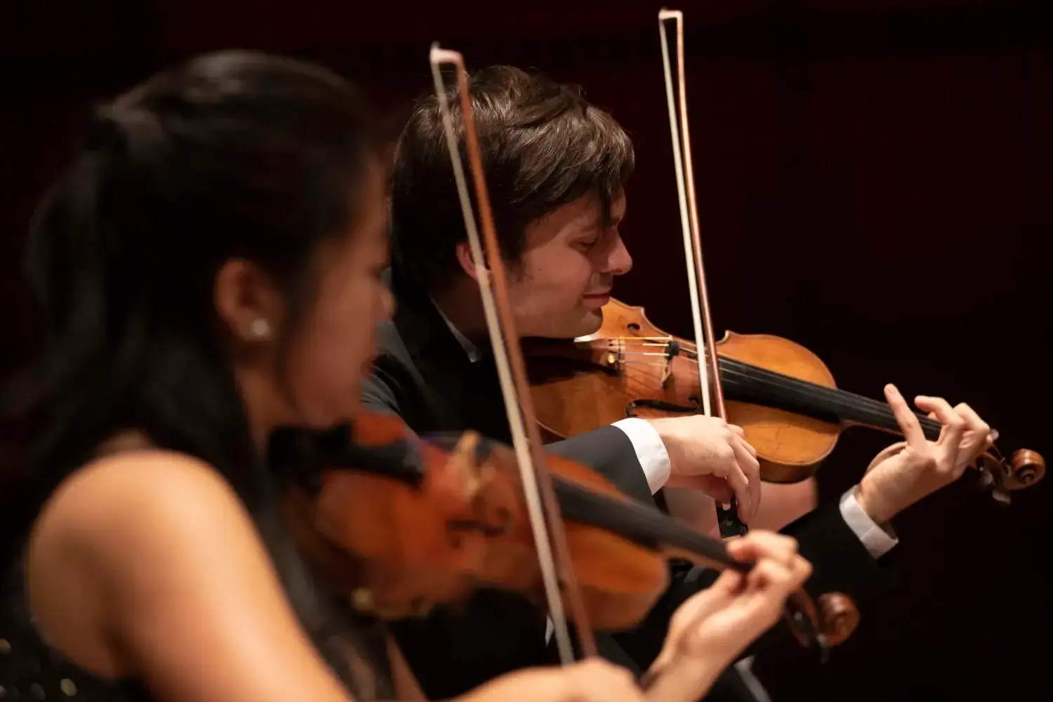 A man in a yellow t-shirt laying on his side in front of a projected version of Hamlet