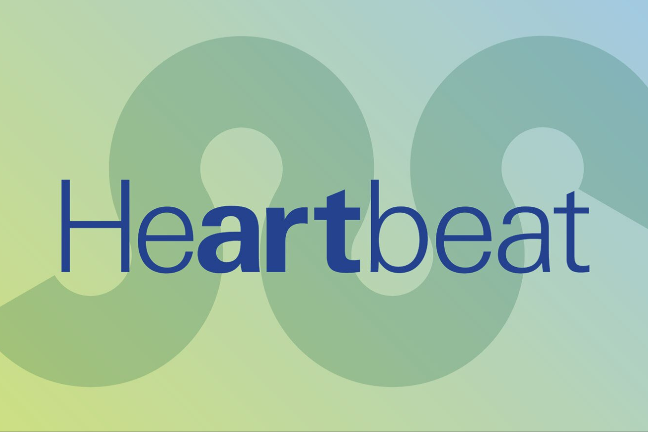 A man in a yellow t-shirt laying on his side in front of a projected version of Hamlet