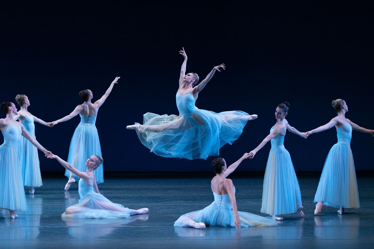 Ballet dancers in white outfits on stage