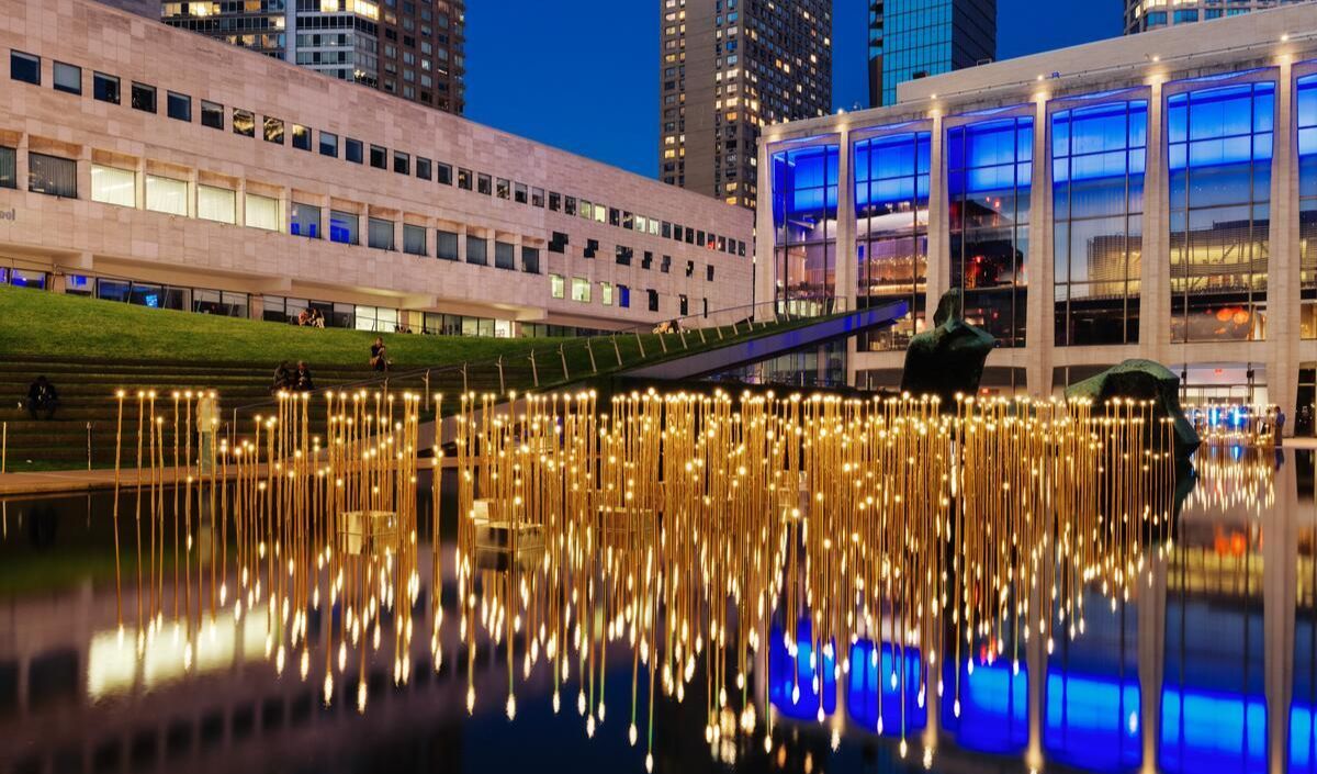 People walking through the Lincoln Center plaza at night