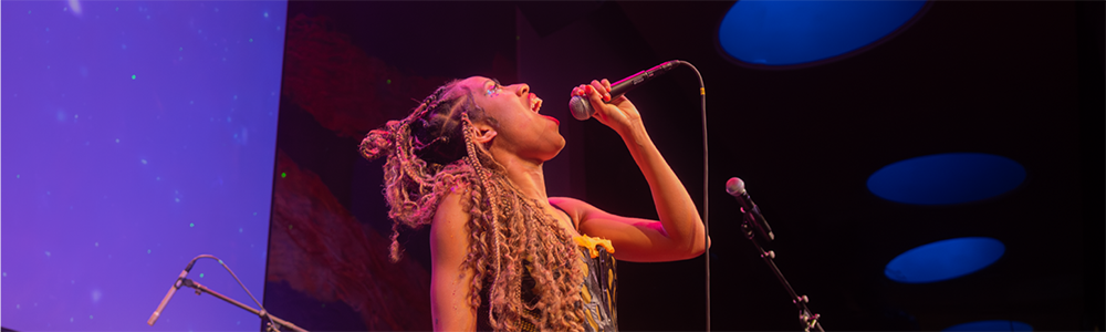 Olivia K sings into a microphone