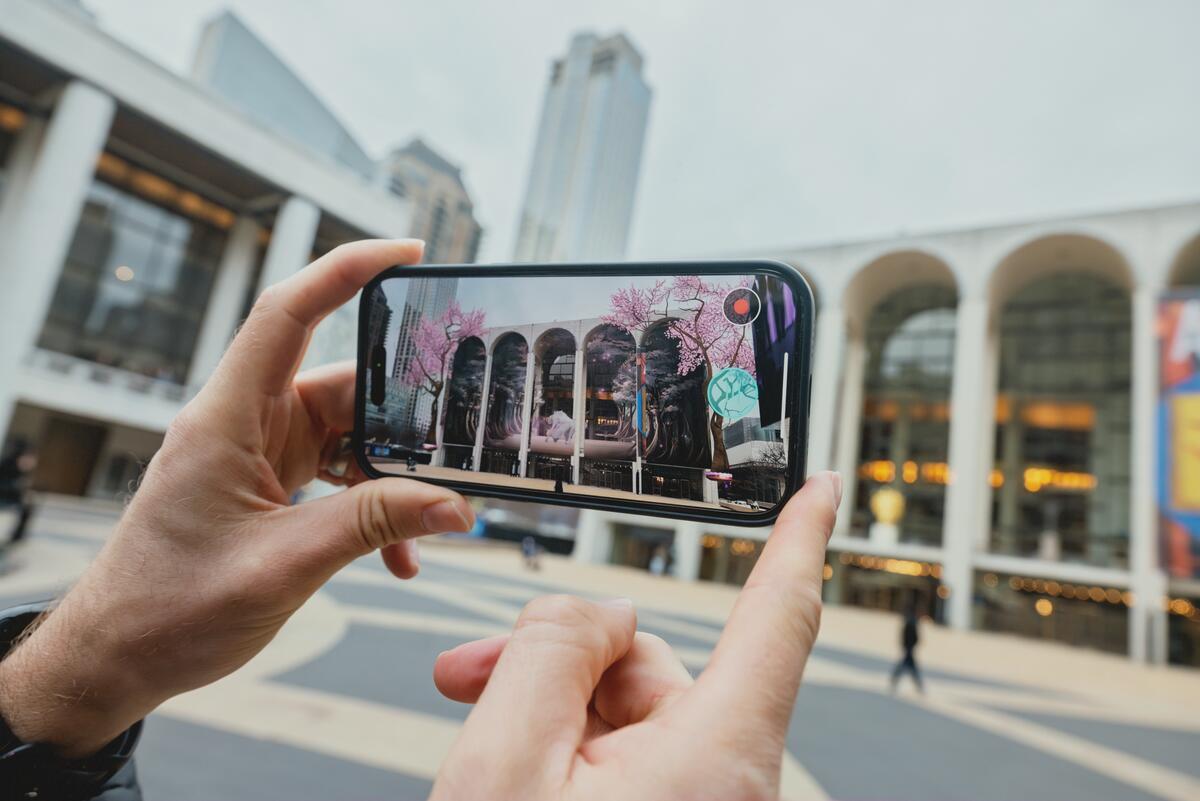 A person holding their phone up to the Metropolitan Opera