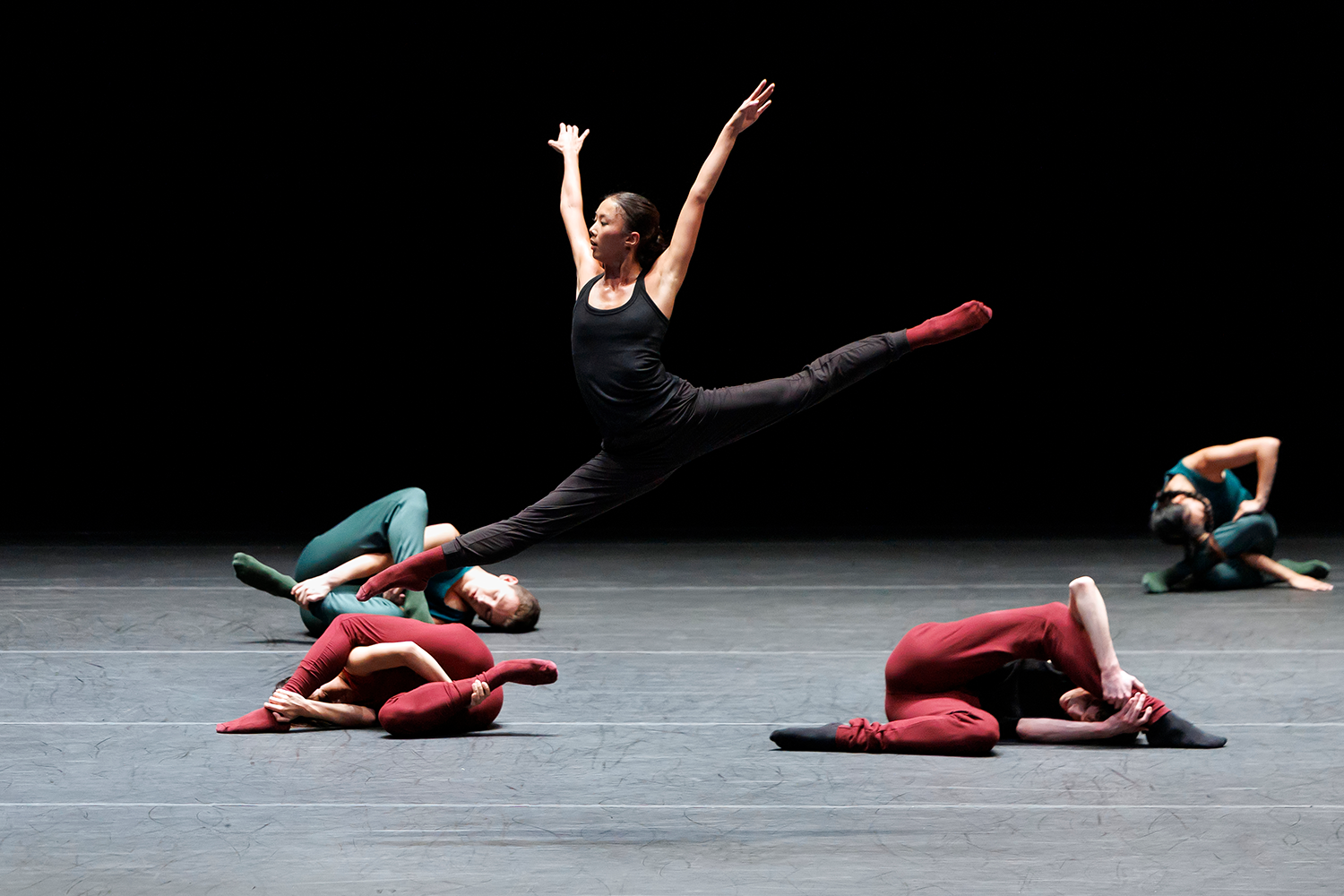 A woman sitting on a plush bench holding a cello