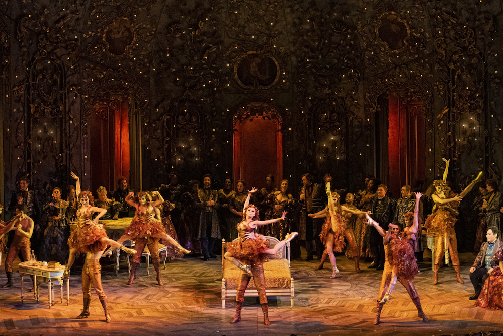 A woman with blonde hair wearing a white dress lying on a marble slab