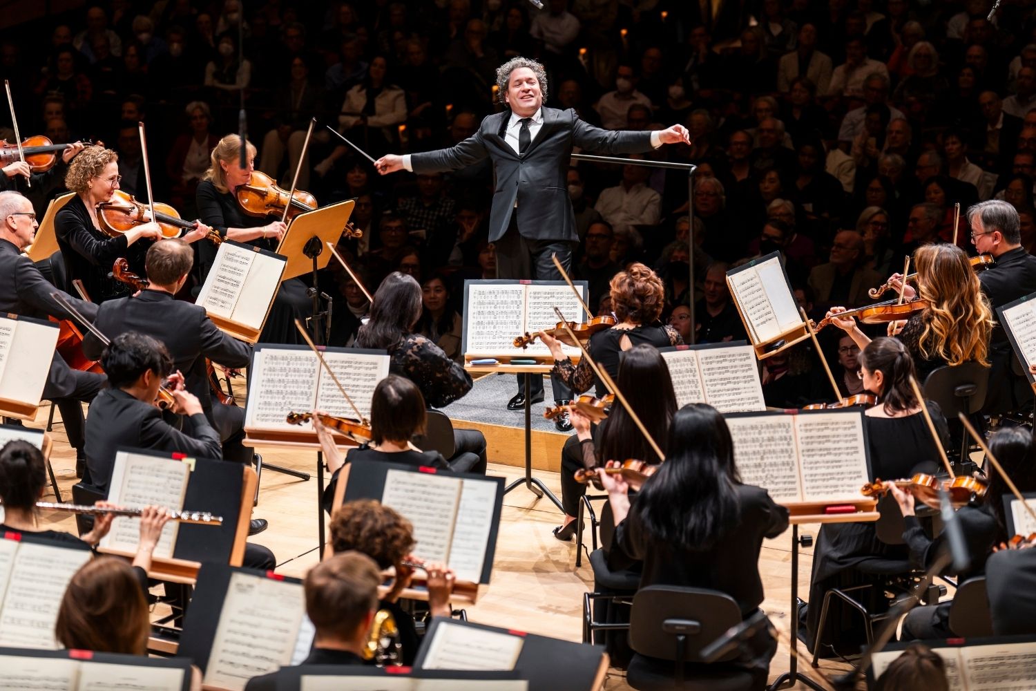 A woman sitting on a plush bench holding a cello
