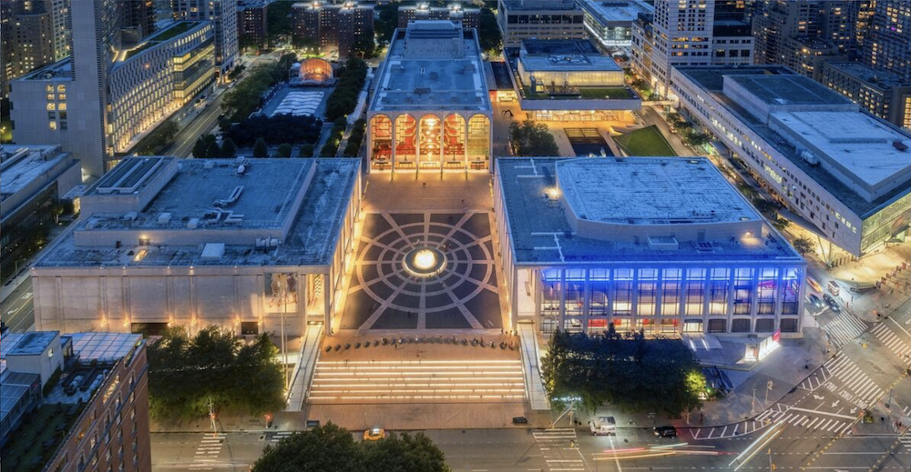 People walking through the Lincoln Center plaza at night