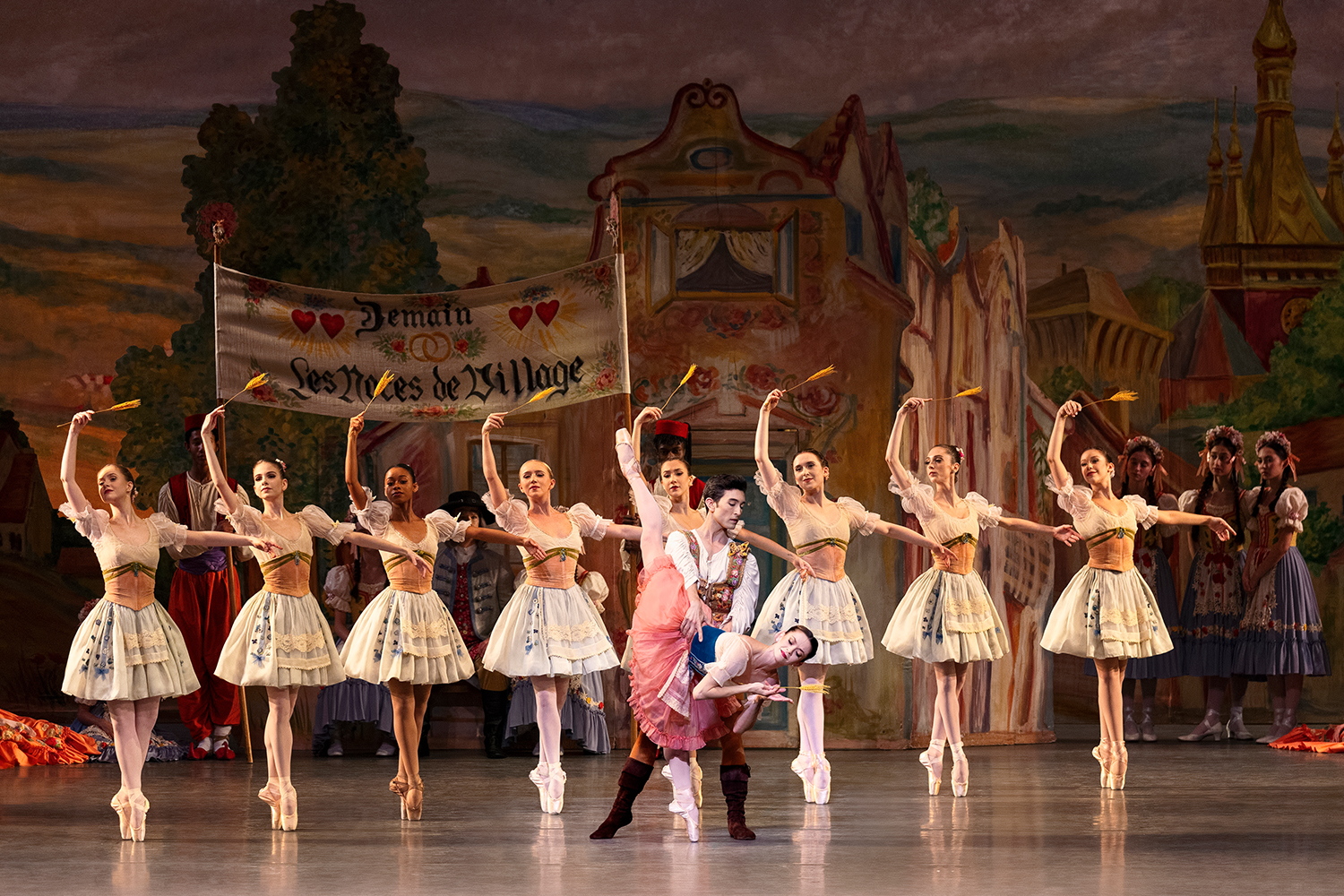 Ballet dancers in white outfits on stage