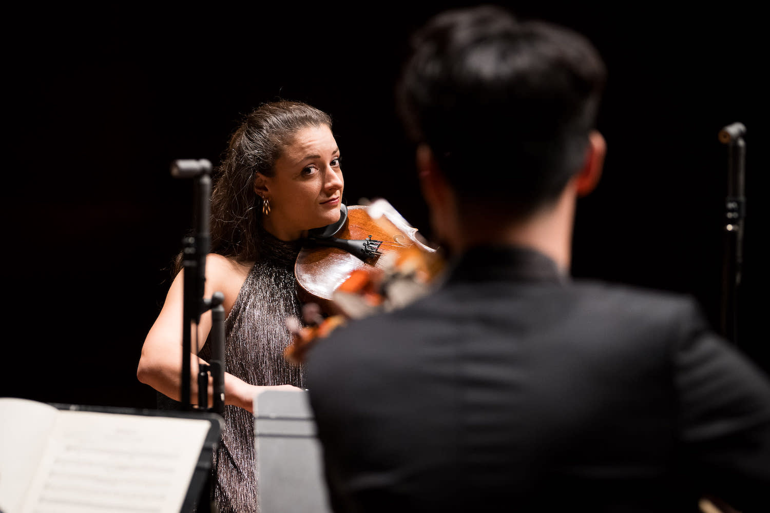 A man in a yellow t-shirt laying on his side in front of a projected version of Hamlet