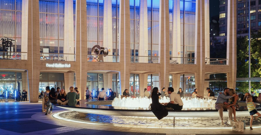 People walking through the Lincoln Center plaza at night