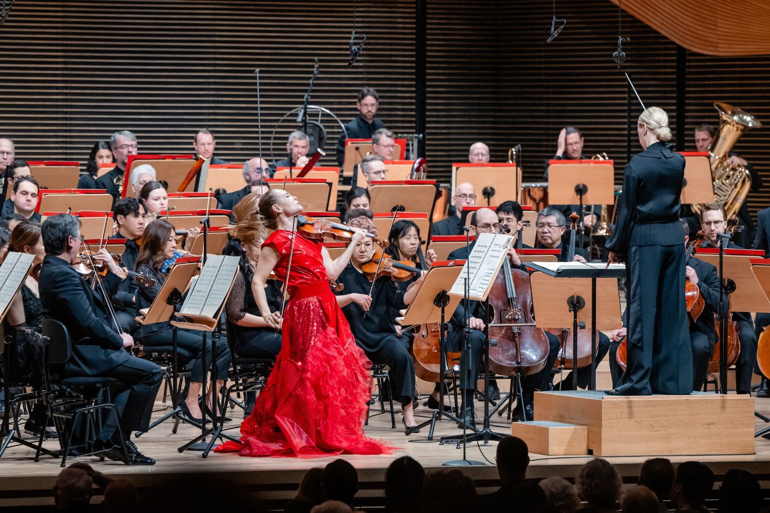 A woman sitting on a plush bench holding a cello