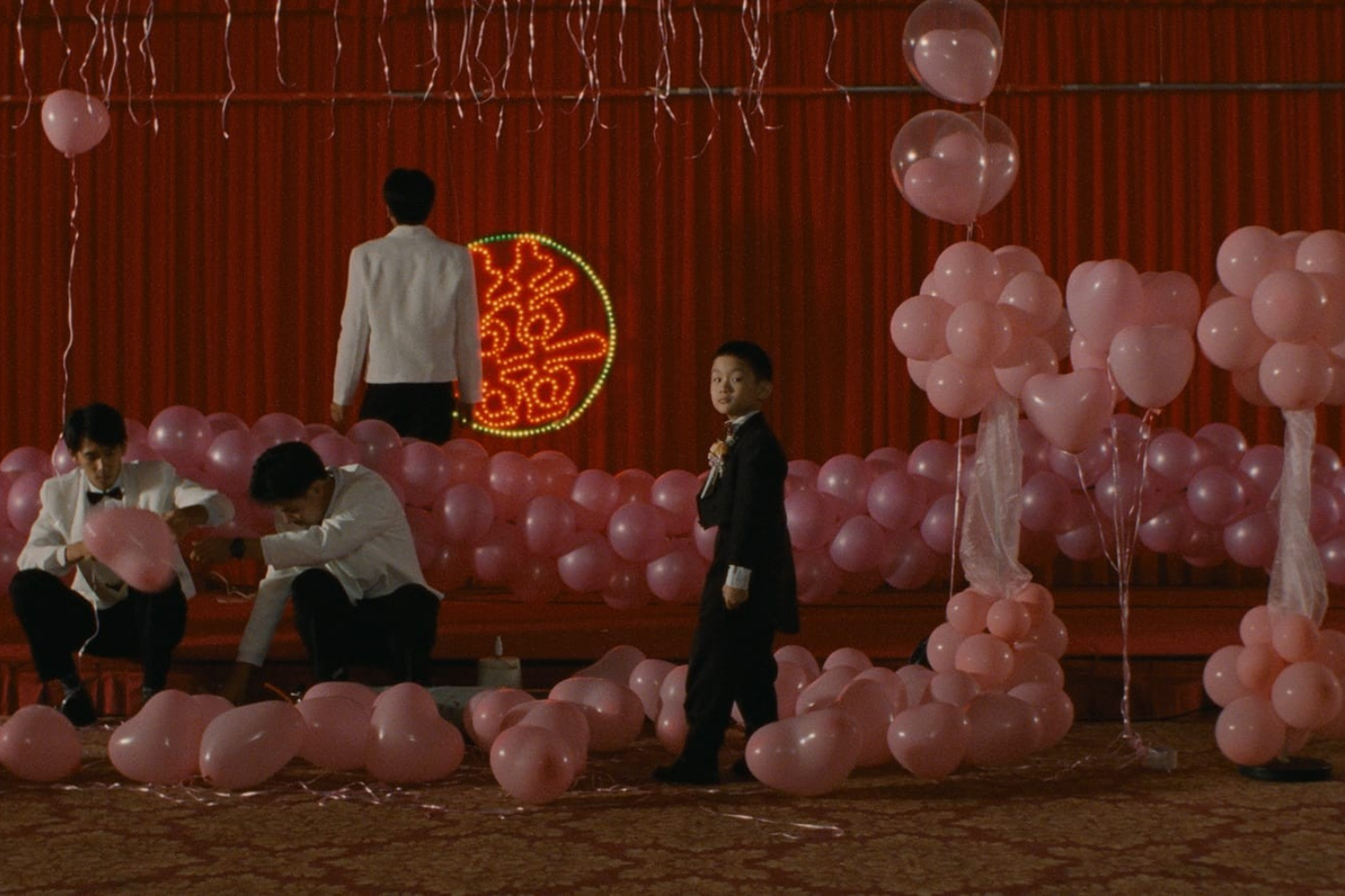 A woman in overalls talking to a man in a black t-shirt