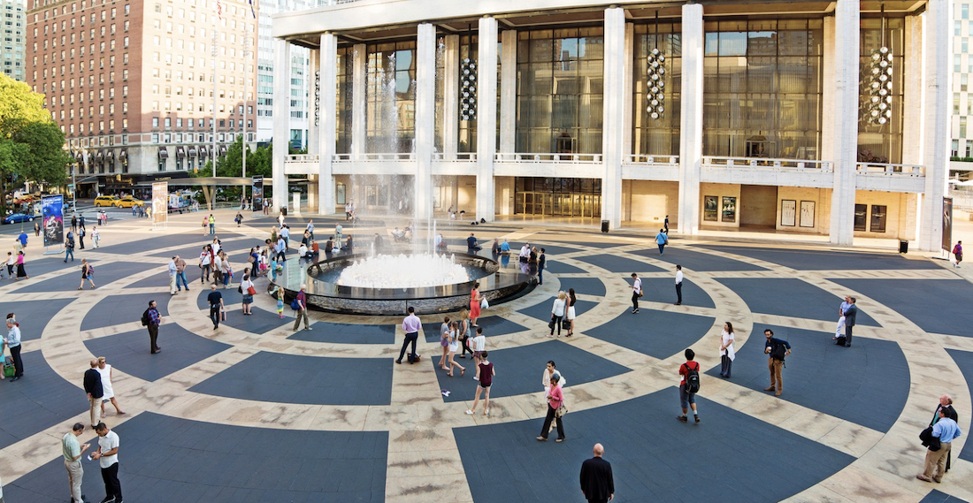 People walking through the Lincoln Center plaza at night