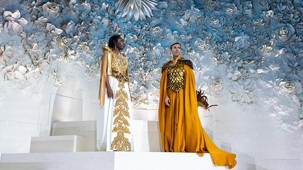 Two performers in elaborate gold costumes on stage