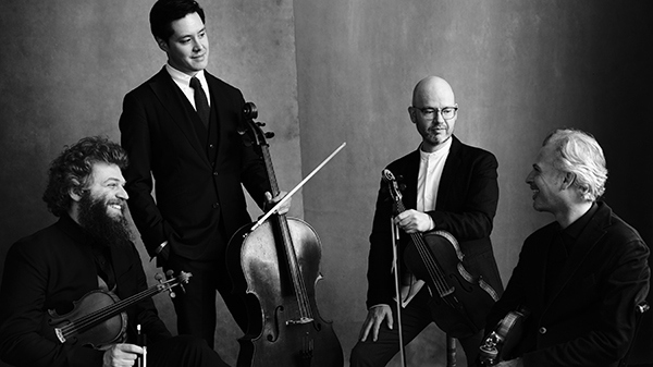 Four men hold stringed instruments